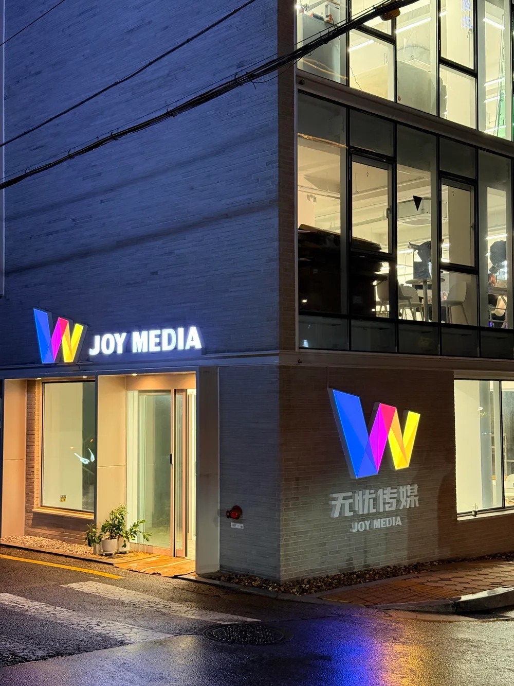 야간 조명이 켜진 조이미디어 오프라인 거점 외관