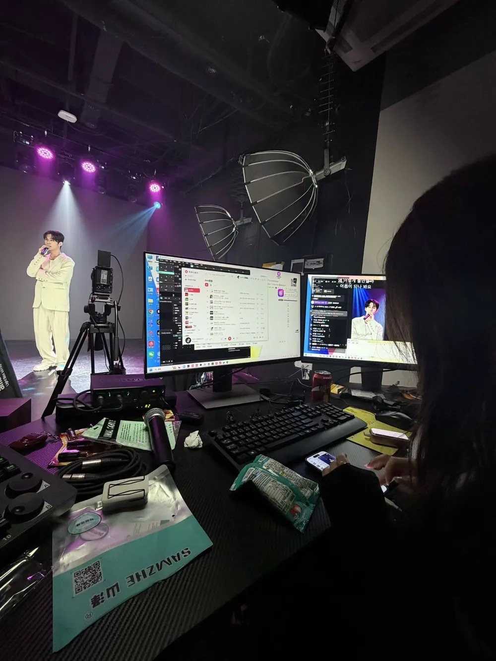 라이브 방송 진행 현장. 조명과 다중 모니터가 설치된 스튜디오.